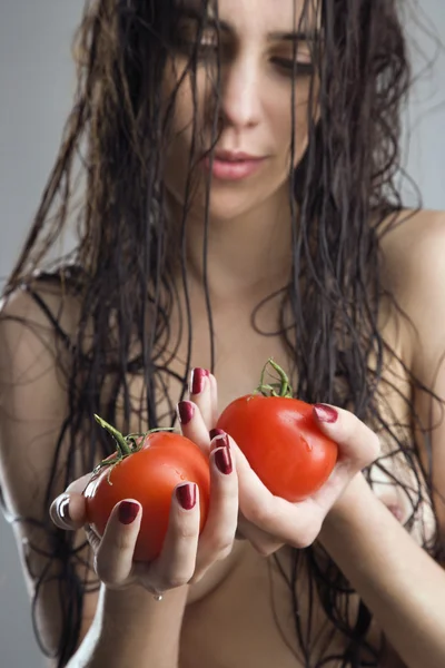 Žena hospodářství rajčata. — Stock fotografie