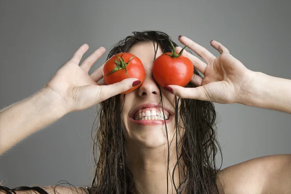 Woman with tomatoes covering eyes. — Stock Photo, Image