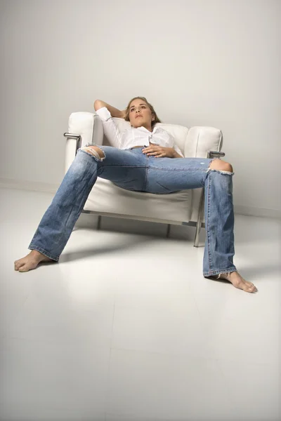 Jovem mulher relaxante em poltrona — Fotografia de Stock