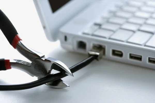 Drahtschneider schneiden Kabel zu Laptop — Stockfoto