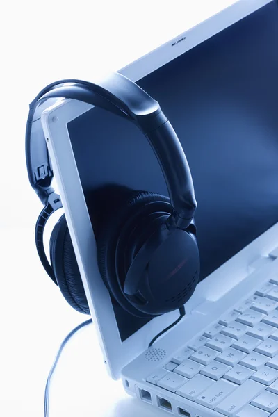Słuchawki wiszące na ekranie laptopa. na białym tle. — Zdjęcie stockowe