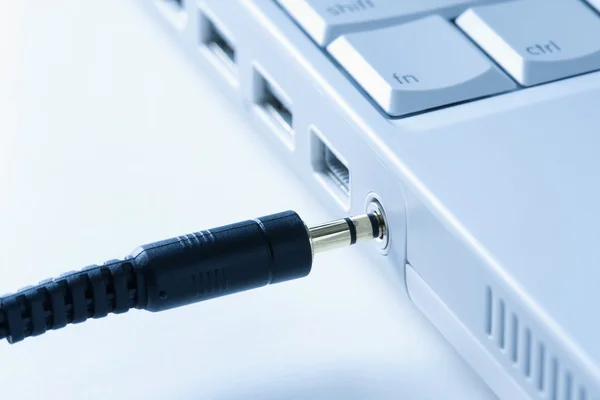 Cable de auriculares que se conecta a la computadora portátil . — Foto de Stock