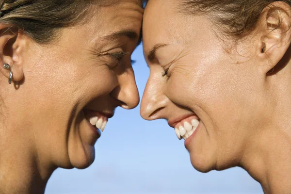 Women head to head smiling. — Stock Photo, Image