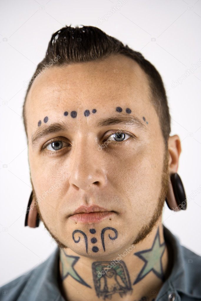 Man with tattoos and piercings.