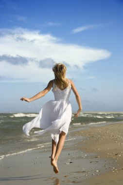 Girl running down the beach. clipart