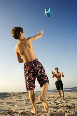 Boy throwing football with dad. clipart