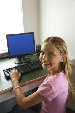 Girl at computer smiling. clipart