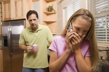 Father watching Daughter on phone clipart