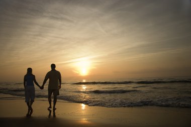 Couple Walking on Beach at Sunset clipart