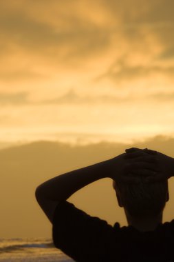 Boy on beach at sunset clipart