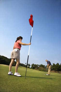 Couple playing golf. clipart