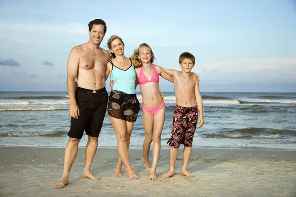Glada leende familjen på stranden. — Stockfoto