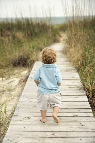 Liten pojke på stranden gångväg. — Stockfoto