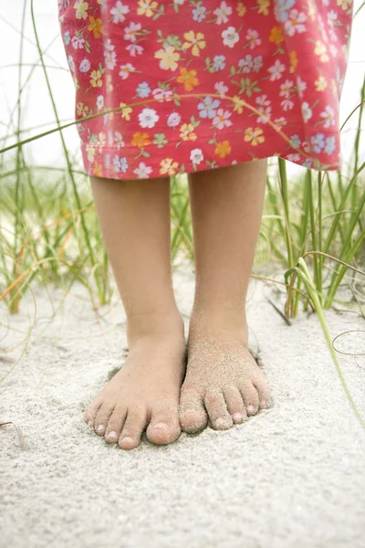 Små flickor fötter i sanden — Stockfoto