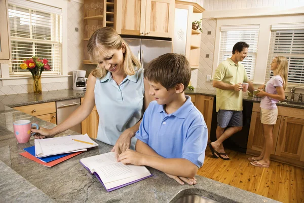 Familie in der Küche macht Hausaufgaben und plaudert. — Stockfoto