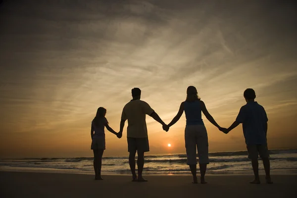 Familjen håller händerna på stranden — Stockfoto