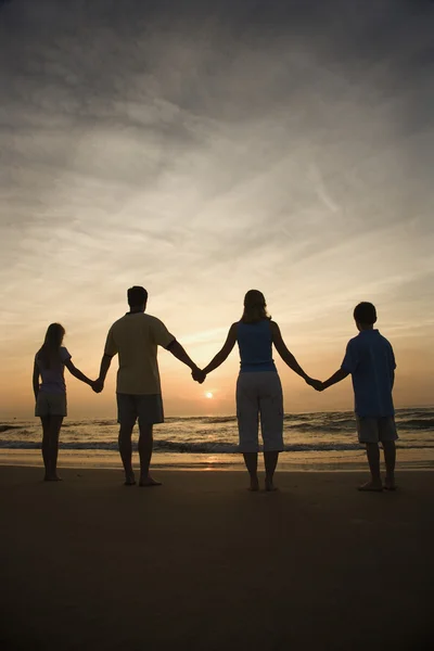 Familia sosteniendo las manos en la playa — Foto de Stock