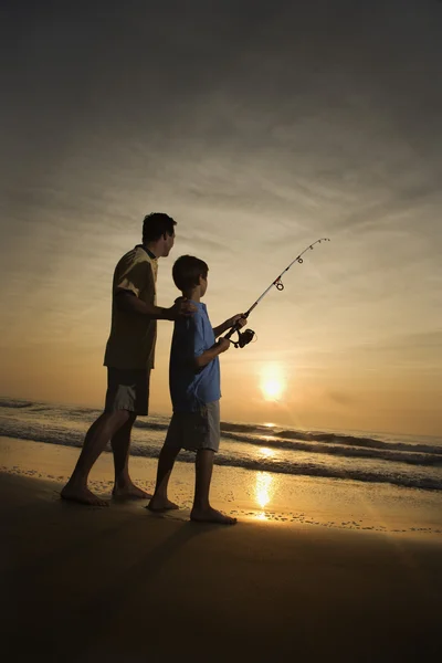 Muž a mladý chlapec rybolov v příboji — Stock fotografie