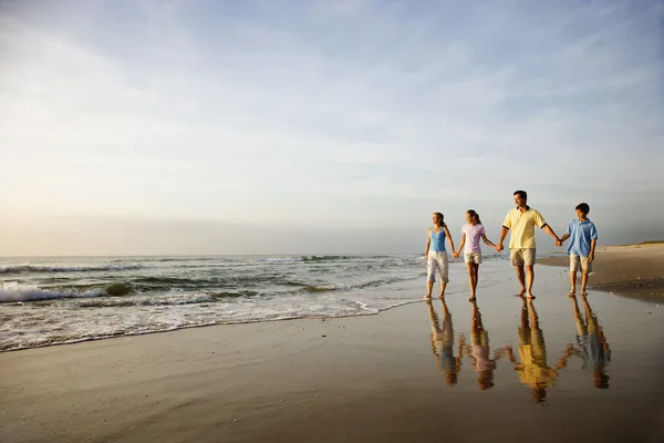 Familia caminando en la playa —  Fotos de Stock
