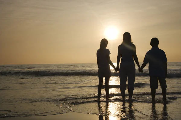 Moeder en kinderen op het strand. — Stockfoto