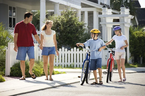 Familie zu Fuß mit Fahrrädern — Stockfoto