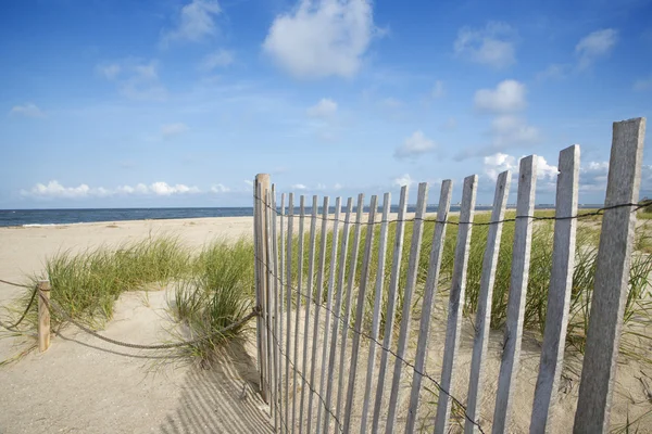 Weathered wooden fence on sand dune. — Stock Photo, Image