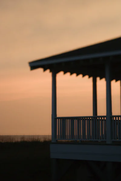 Beachfront porch silhouetted at sunset — Stock Photo, Image