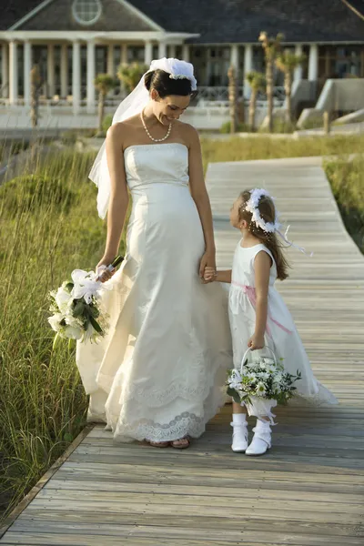 Bruid en bloemenmeisje wandelen. — Stockfoto