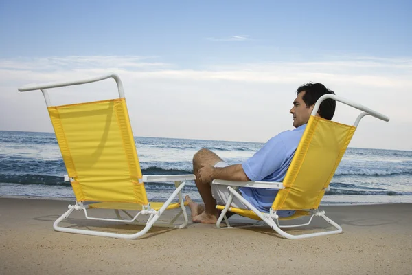 Man sitter på stranden ensam — Stockfoto