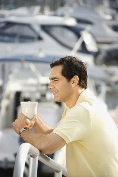 Man holding coffee cup at harbor. — Stock Photo, Image