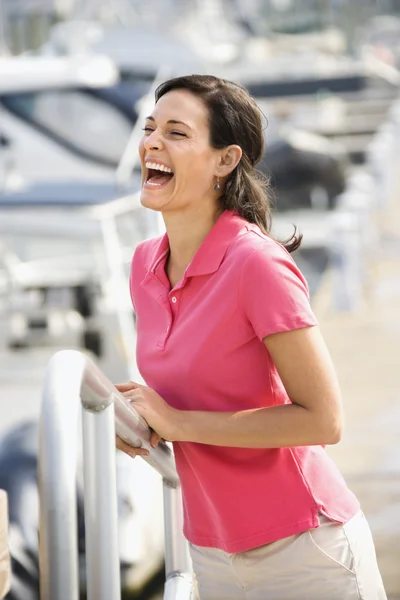 Frau hält Geländer und lacht. — Stockfoto
