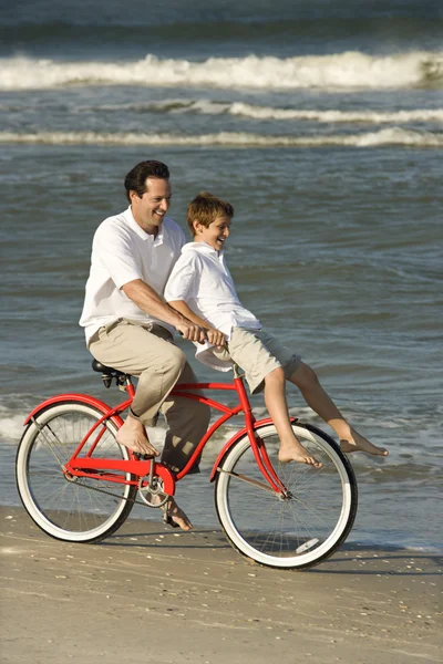 Pappa ridning cykel med son . Stockfoto
