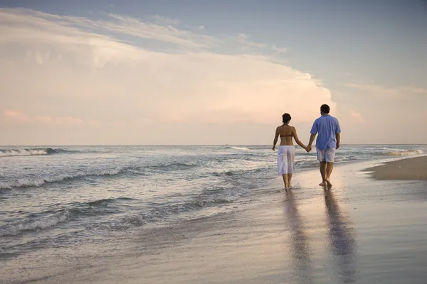 在海滩上散步的夫妻 免版税图库图片