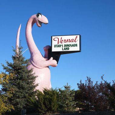Dinosaur holding Utah sign. clipart