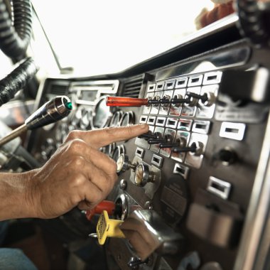 Interior of male hand pressing switch in tractor trailer. clipart