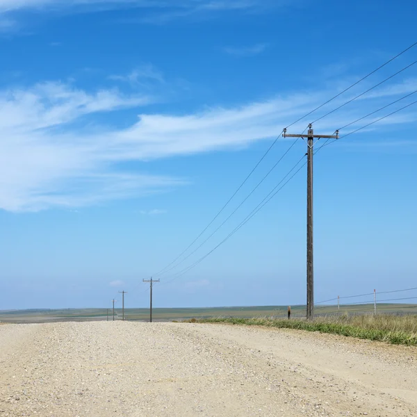 Лінії електропередач на сільській дорозі . — стокове фото