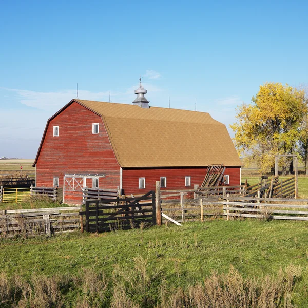 Červená stodola a plot. — Stock fotografie