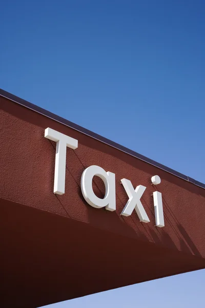 Segno di taxi su un muro marrone — Foto Stock