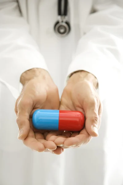 Doktore, drží obří pilulku. — Stock fotografie