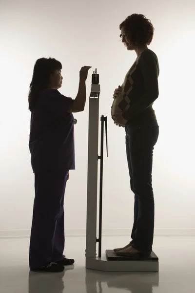 Pregnant woman being weighed. — Stock Photo, Image
