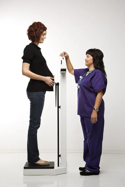 Pregnant woman being weighed. — Stock Photo, Image