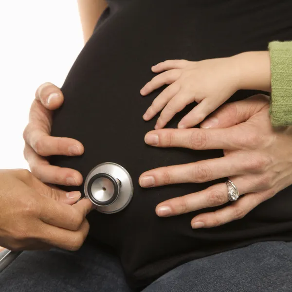 Stethoscope on pregnant belly. — Stock Photo, Image