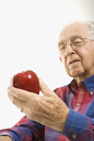 Пожилой человек держит яблоко . — стоковое фото