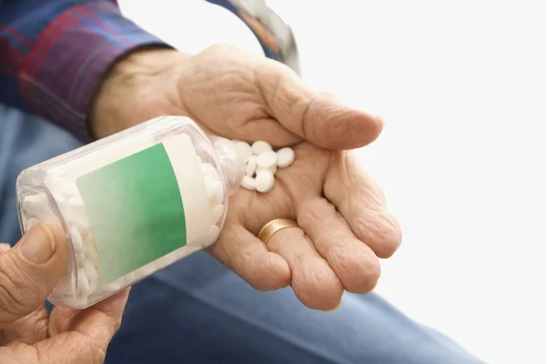 Man pouring pills into hand. — Stock Photo, Image