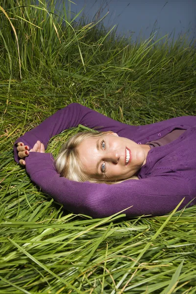 Mulher deitada na grama. — Fotografia de Stock