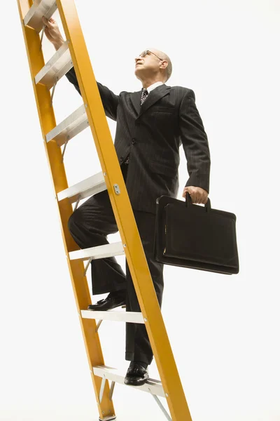 Карабкающийся по лестнице бизнесмен . — стоковое фото