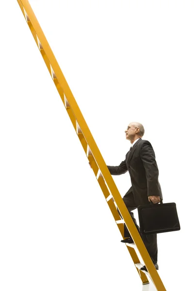 Карабкающийся по лестнице бизнесмен . — стоковое фото