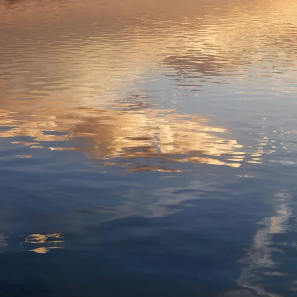 Zonsondergang op water. Stockfoto