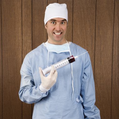 Surgeon holding syringe. clipart