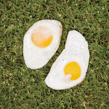 Two fried eggs on grass. clipart